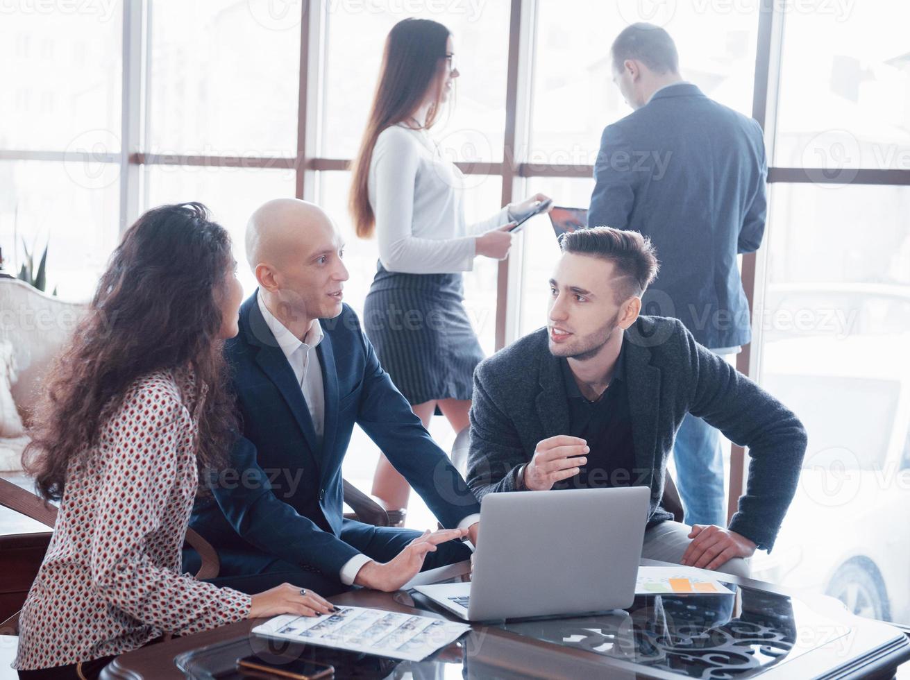 jovem equipe de colegas de trabalho discutindo grandes negócios no moderno escritório de coworking. conceito de trabalho em equipe foto