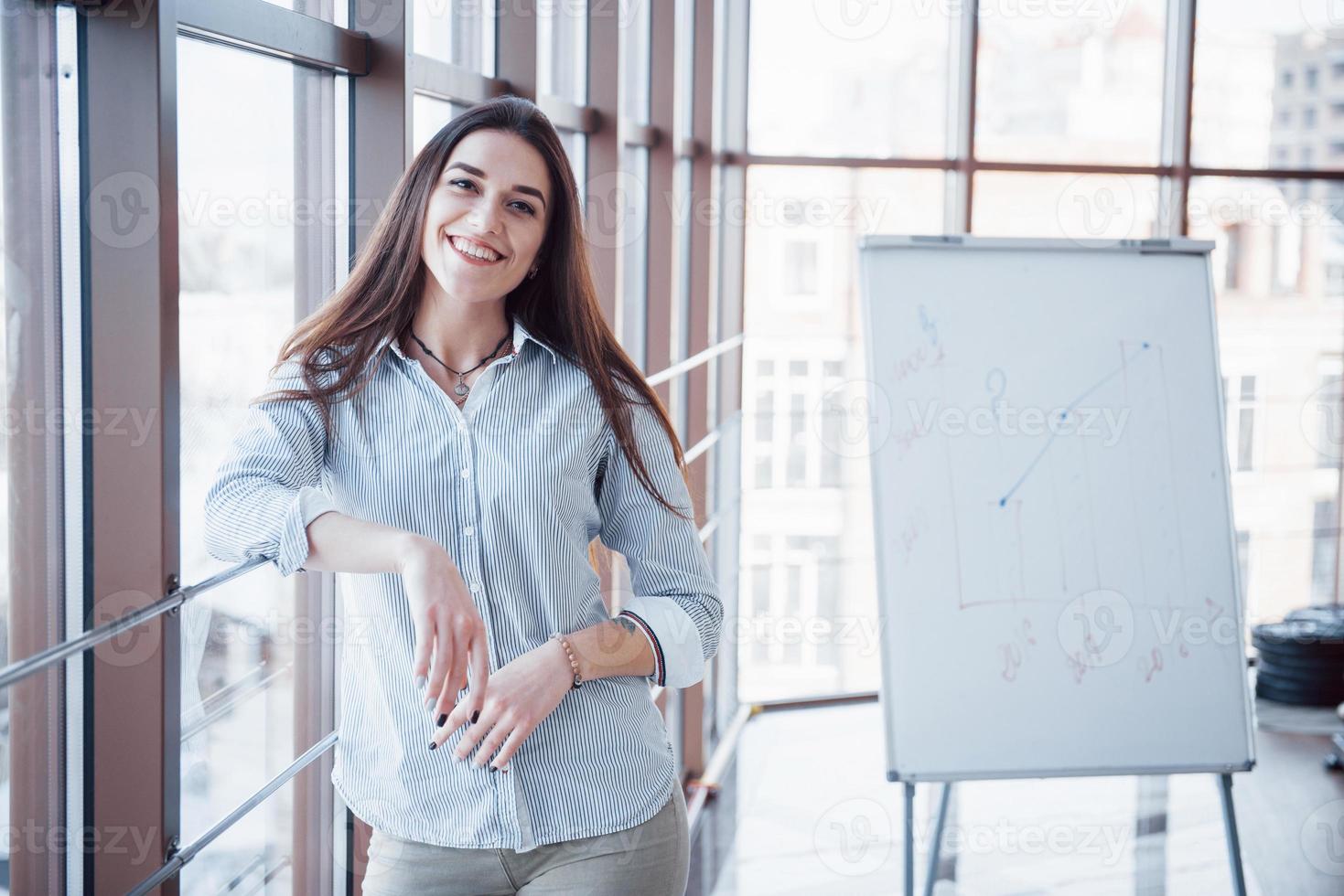 retrato de uma jovem sorridente mulher de negócios no local de trabalho foto