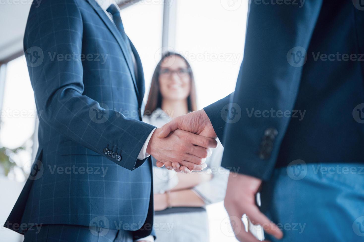 dois confiante homem de negócios apertando as mãos durante uma reunião no escritório, sucesso, negociação, saudação e conceito de parceiro foto