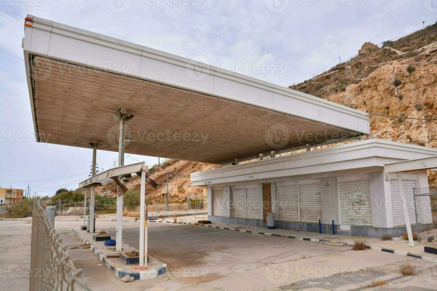 a esvaziar gás estação com uma ampla construção dentro a fundo foto