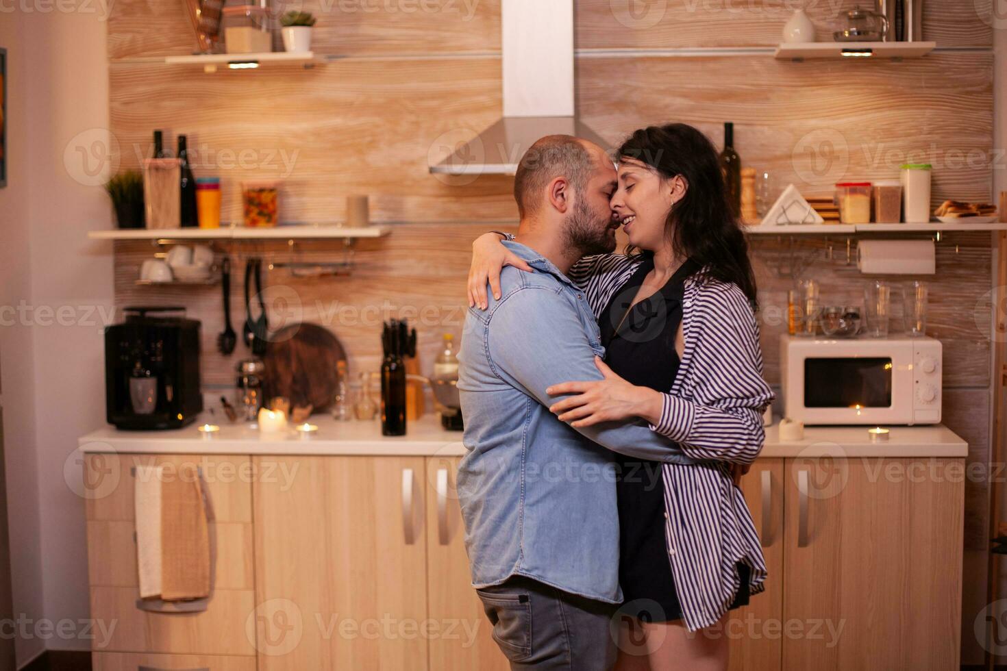 marido abraços esposa durante relação celebração. feliz dentro amor casal jantar juntos às lar, desfrutando a refeição, sorridente, tendo diversão, a comemorar seus aniversário. foto