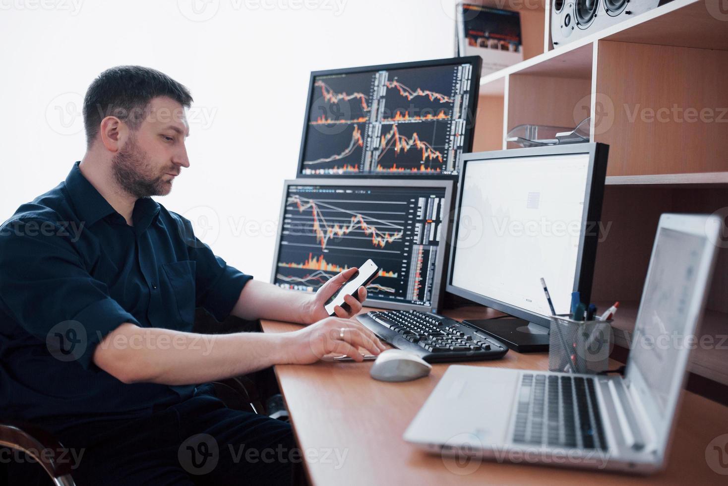 o corretor da bolsa em camisa está trabalhando em uma sala de monitoramento com telas de exibição. conceito gráfico de finanças de forex de negociação de bolsa de valores. empresários negociando ações online foto