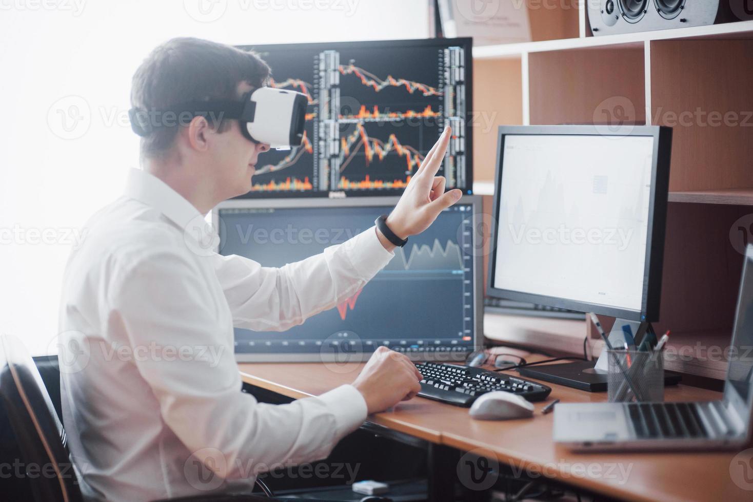 empresário na negociação de realidade virtual no mercado de ações. várias telas de computador cheias de gráficos e análises de dados em segundo plano foto