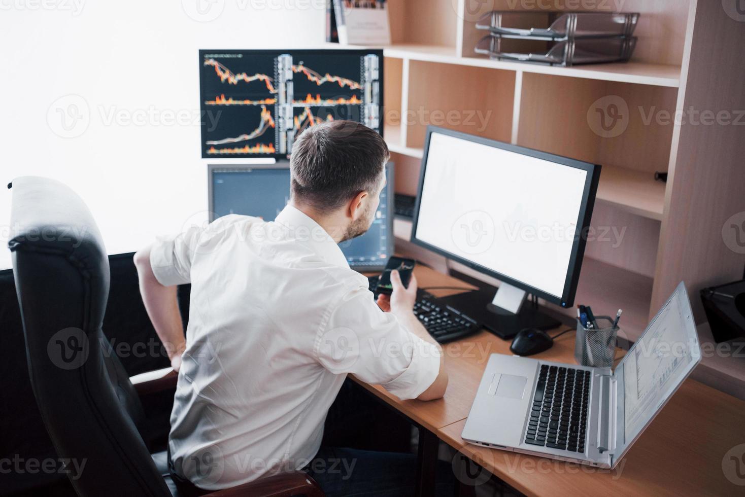 o corretor da bolsa em camisa está trabalhando em uma sala de monitoramento com telas de exibição. conceito gráfico de finanças de forex de negociação de bolsa de valores. empresários negociando ações online foto