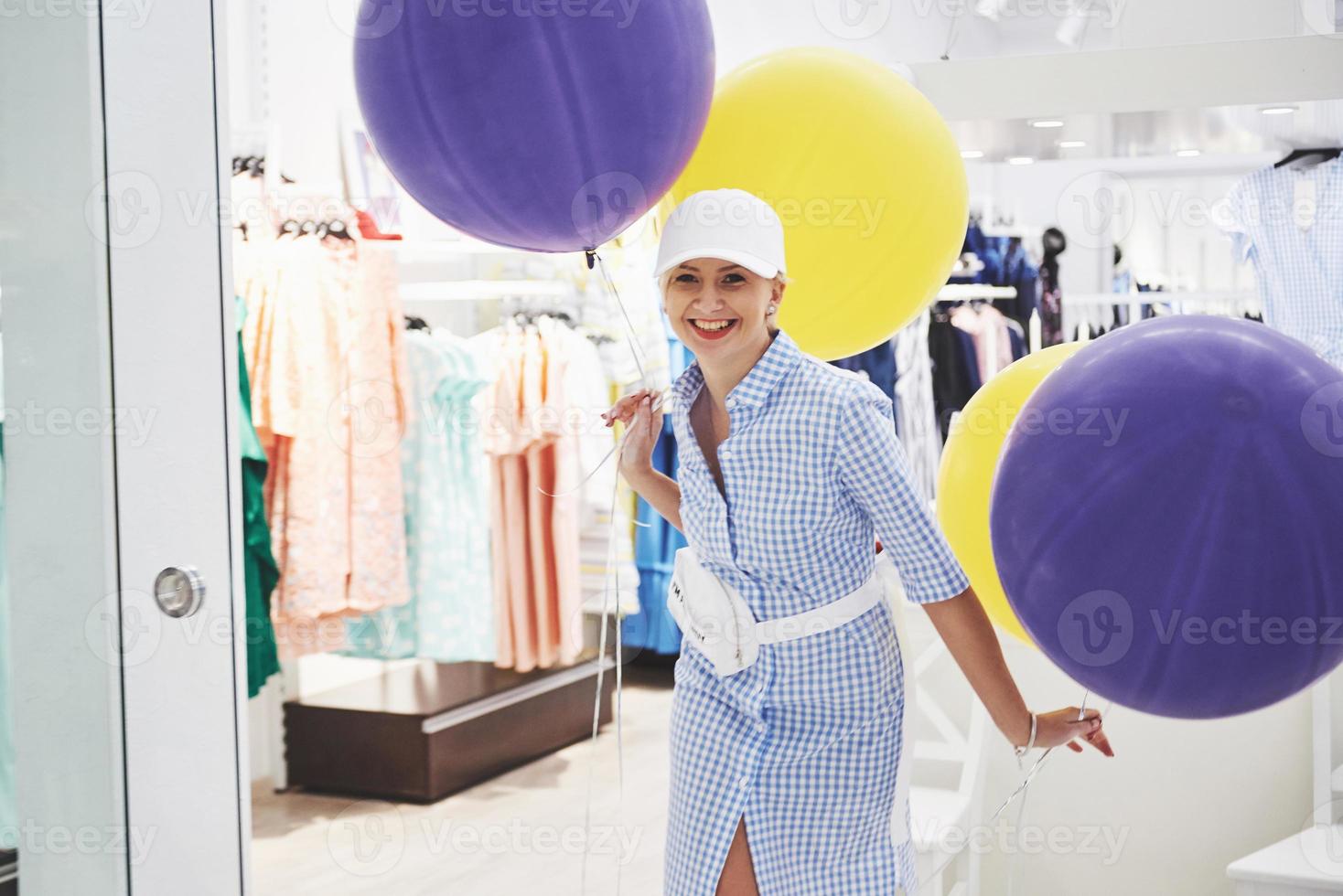 conceito de venda, moda, consumismo e pessoas - jovem feliz com sacolas de compras, escolhendo roupas em um shopping ou loja de roupas foto