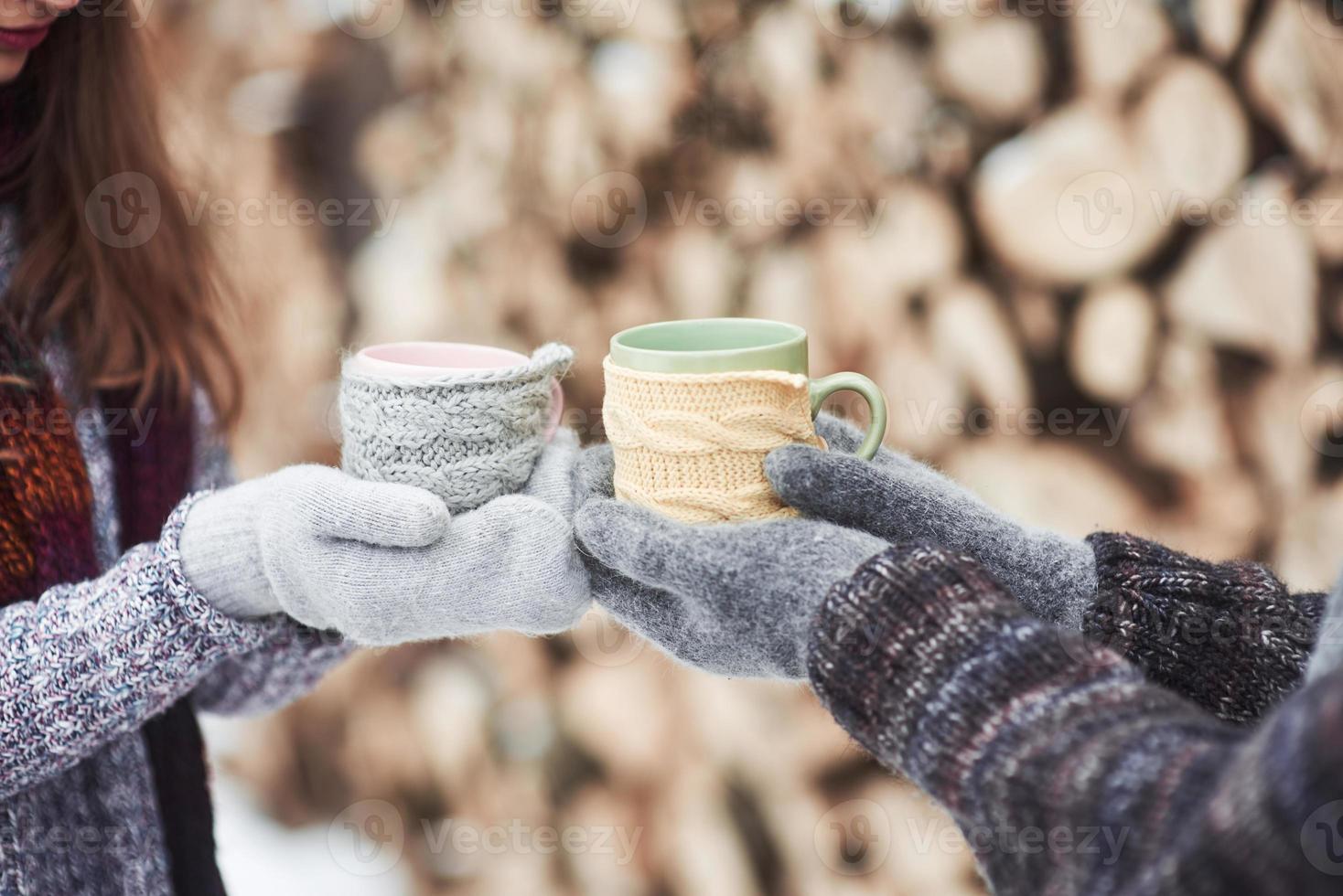 casal de mãos de luvas pegando uma caneca com chá quente em Winter Park foto