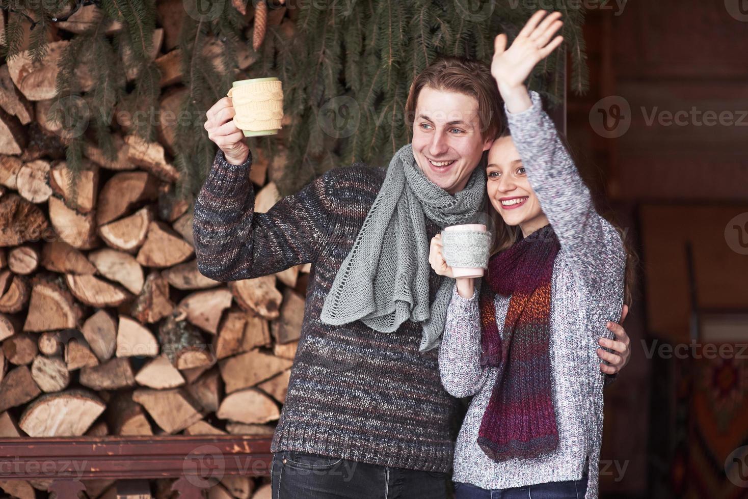 foto de um homem feliz e uma linda mulher com xícaras ao ar livre no inverno. férias e férias de inverno. casal de Natal de homem e mulher feliz bebem café quente. ola vizinhos