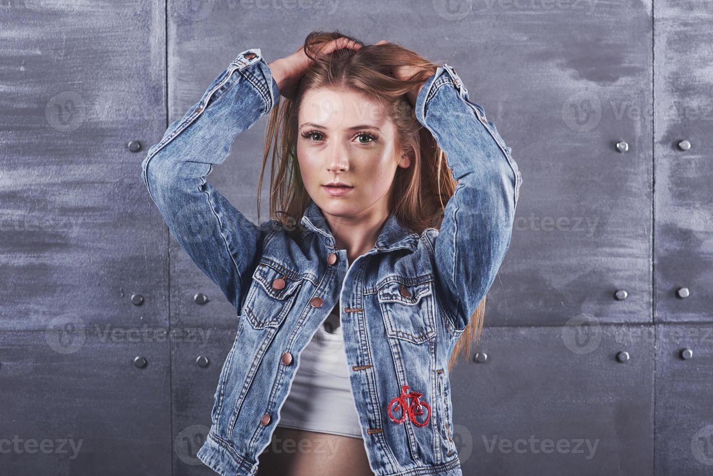 moda, roupas, conceito de pessoas. mulher jovem e atraente sexy com jaqueta jeans. garota está posando no estúdio foto