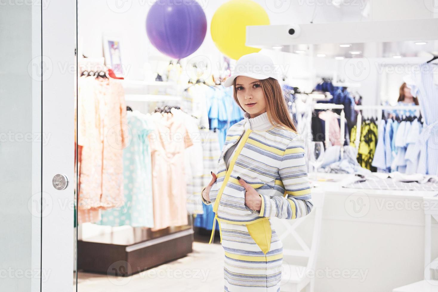 conceito de venda, moda, consumismo e pessoas - jovem feliz com sacolas de compras, escolhendo roupas em um shopping ou loja de roupas foto