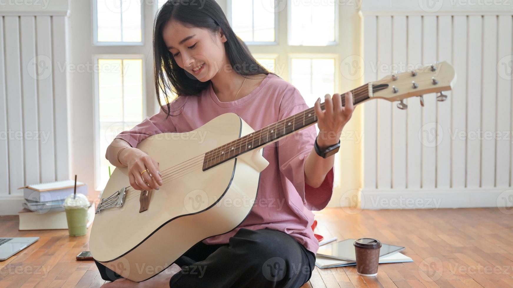 foto cortada de uma adolescente tocando guitarra enquanto ficava em casa enquanto colocava o vírus covid-19 em quarentena.