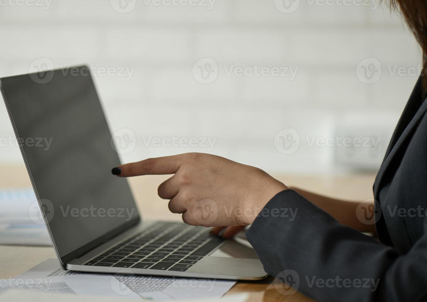 funcionárias estão usando um laptop na mesa do escritório. foto