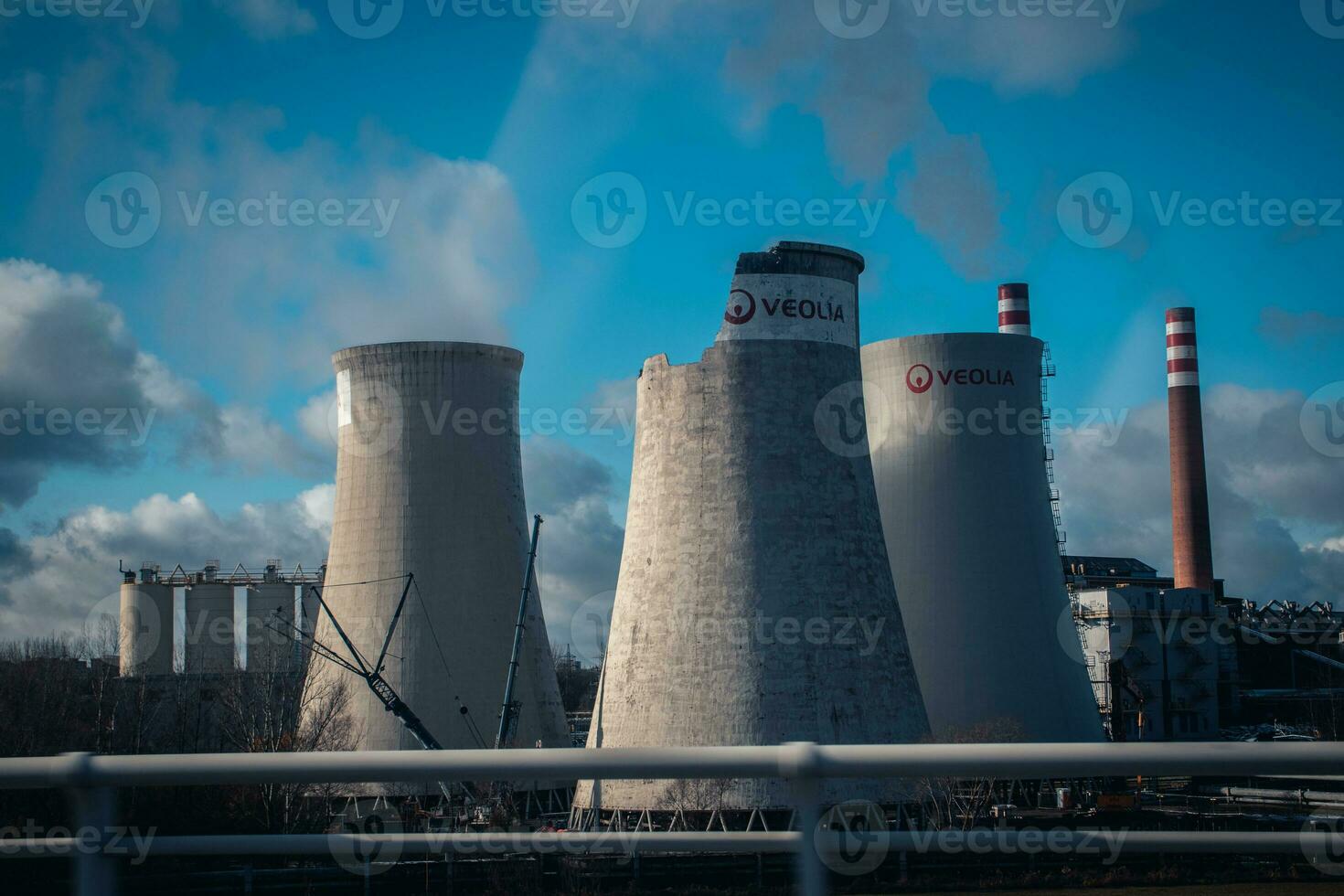 construção uma nuclear poder plantar torres. grande chaminés ao lado estrada com parcialmente nublado céu. foto