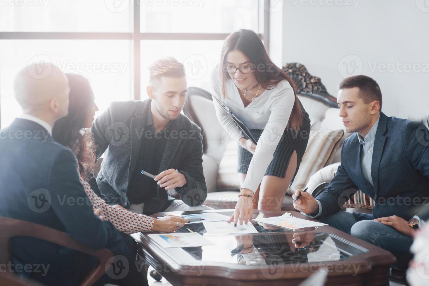 jovem equipe de colegas de trabalho discutindo grandes negócios no moderno escritório de coworking. conceito de trabalho em equipe foto