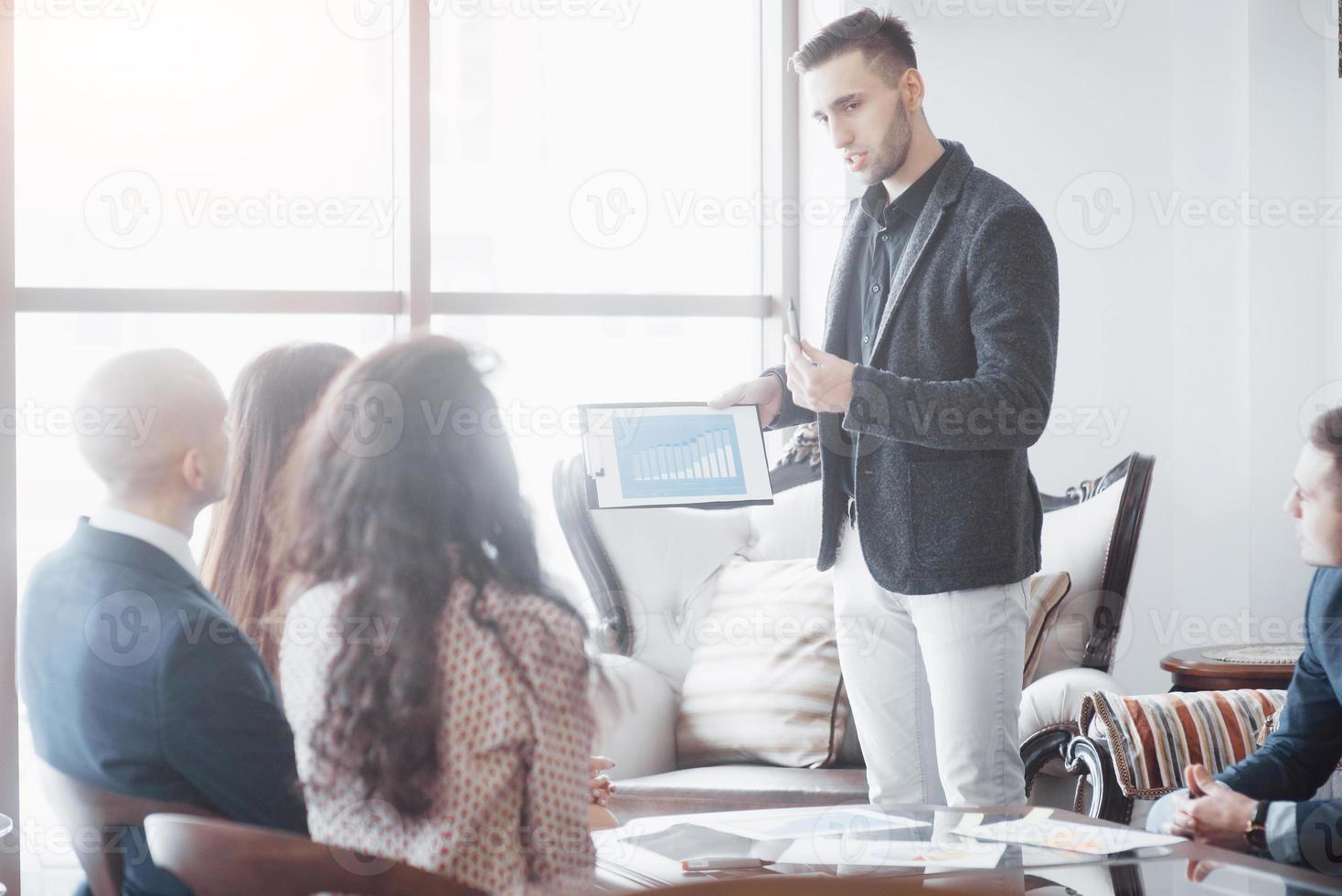 jovem equipe de colegas de trabalho discutindo grandes negócios no moderno escritório de coworking. conceito de trabalho em equipe foto