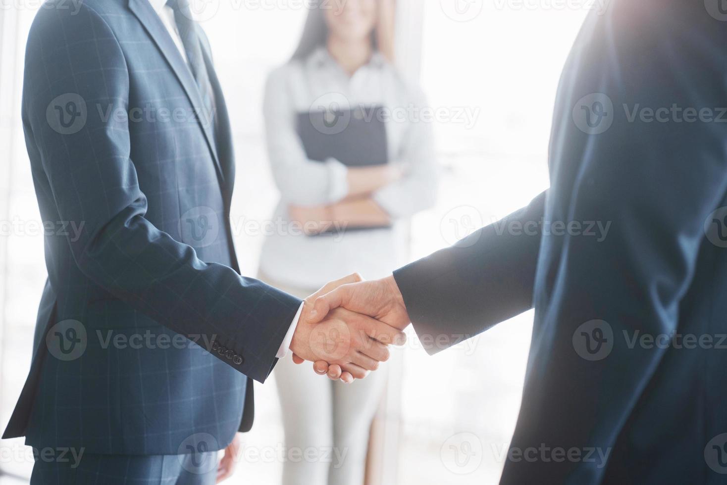 Empresários apertando as mãos, terminando uma reunião foto