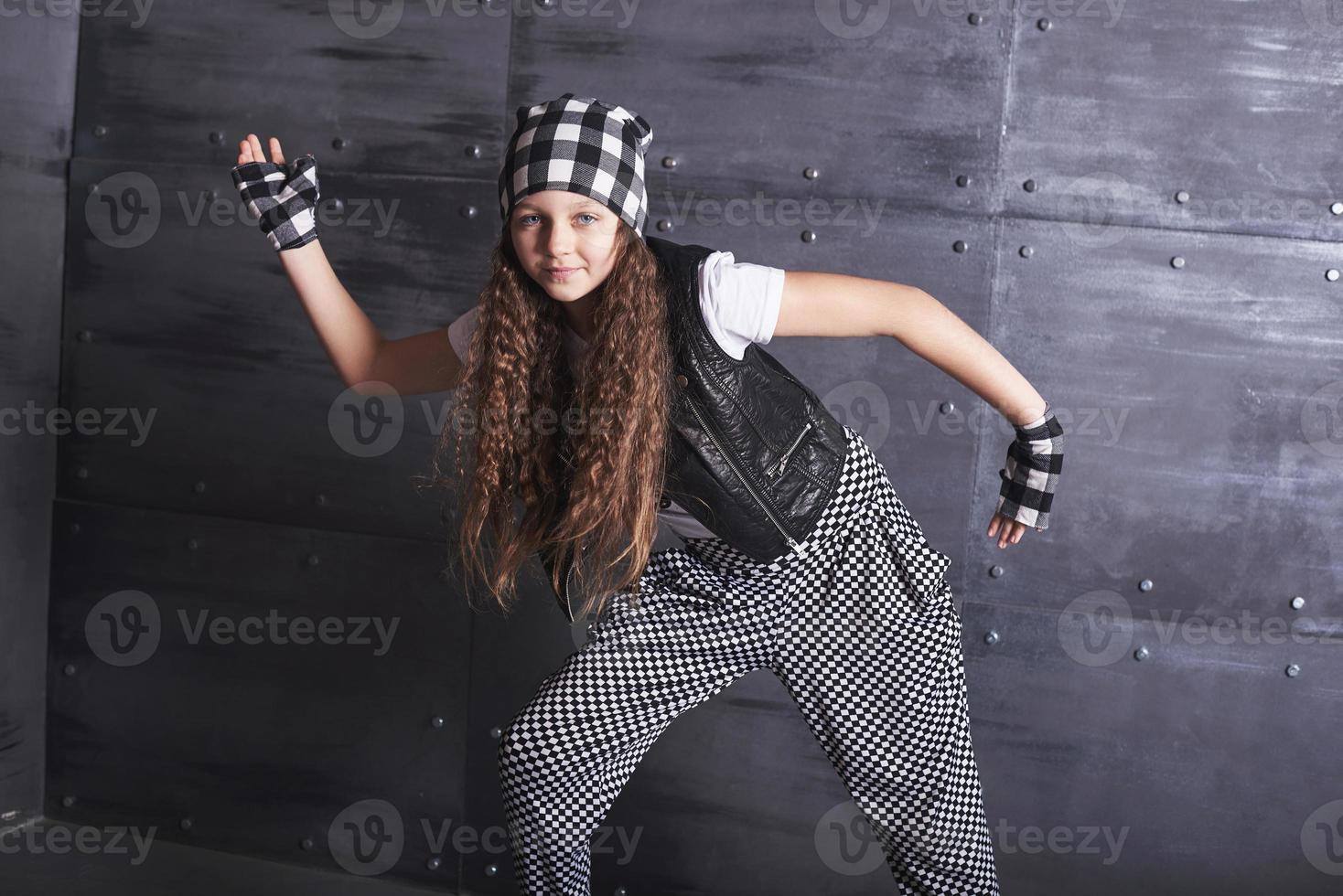 linda jovem dançando com uma roupa da moda em um fundo de grunge foto