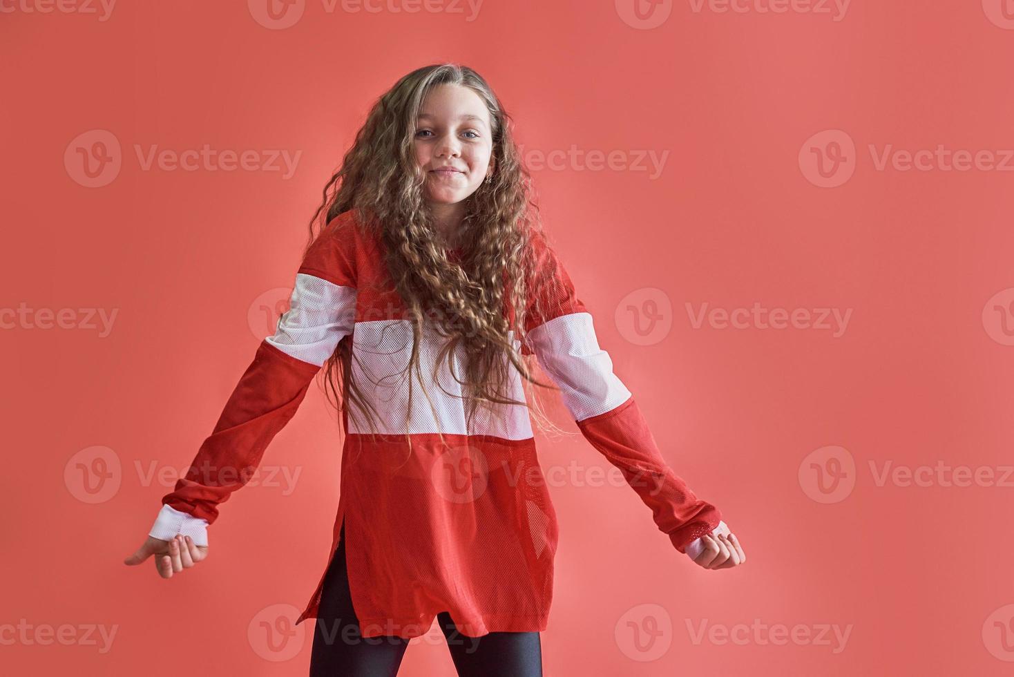 jovem linda linda garota dançando sobre fundo vermelho, estilo hip-hop moderno slim adolescente pulando foto