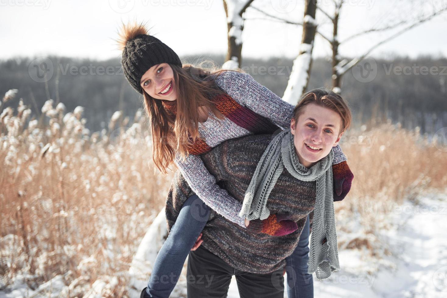 jovem casal feliz se diverte na neve fresca em um lindo dia ensolarado de inverno nas férias foto