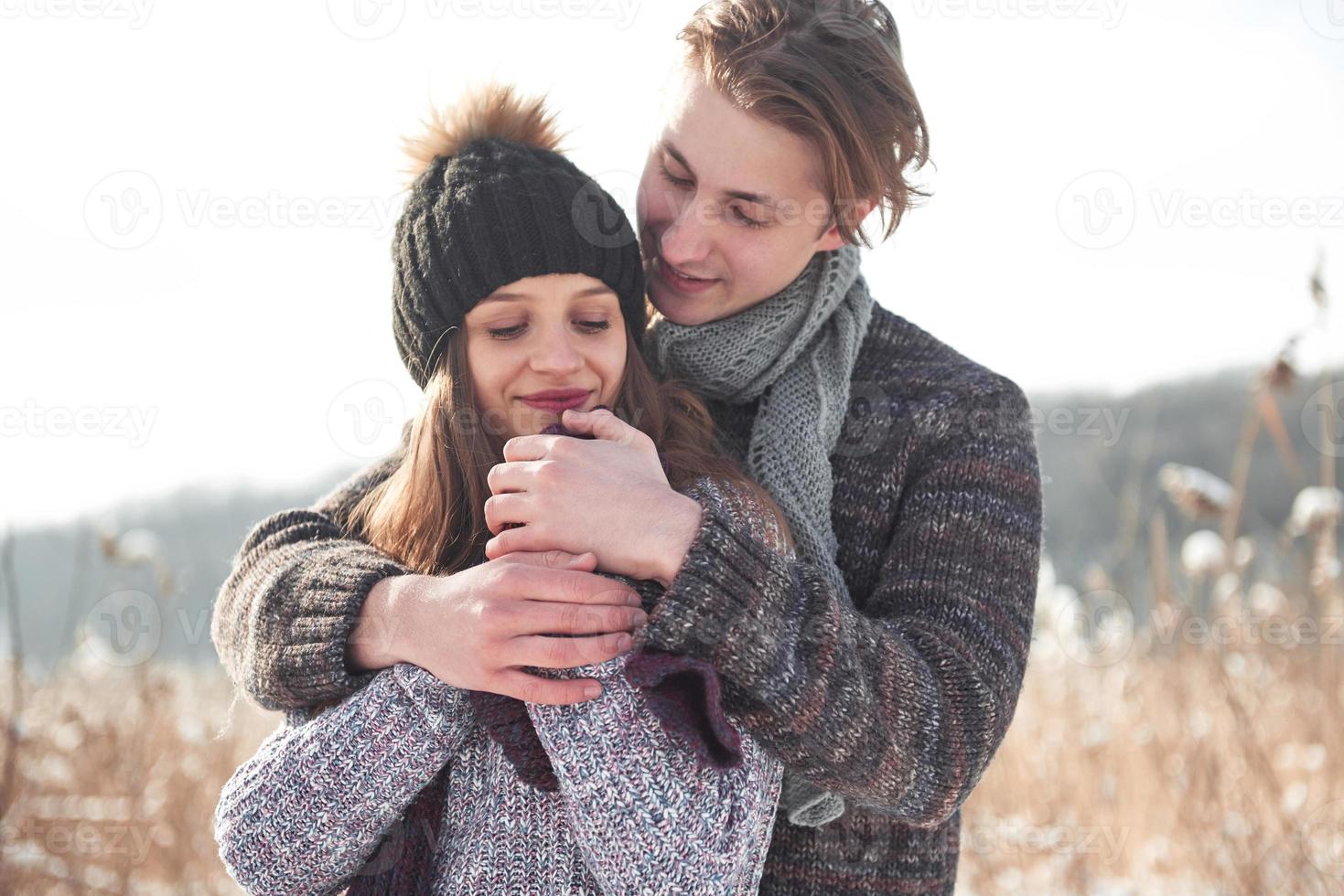 casal se diverte e ri. beijo. casal jovem hippie abraçando uns aos outros em winter park. história de amor de inverno, um lindo casal jovem e elegante. conceito de moda inverno com namorado e namorada foto