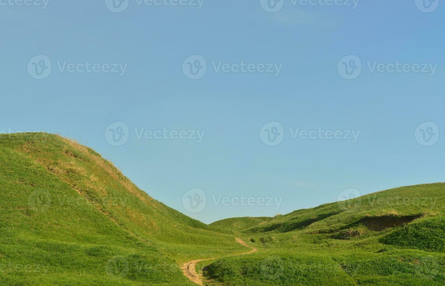 paisagem com um caminho pisado, passando por um maravilhoso terreno montanhoso verde. foto de belo espaço de relevo paisagístico com um caminho fino