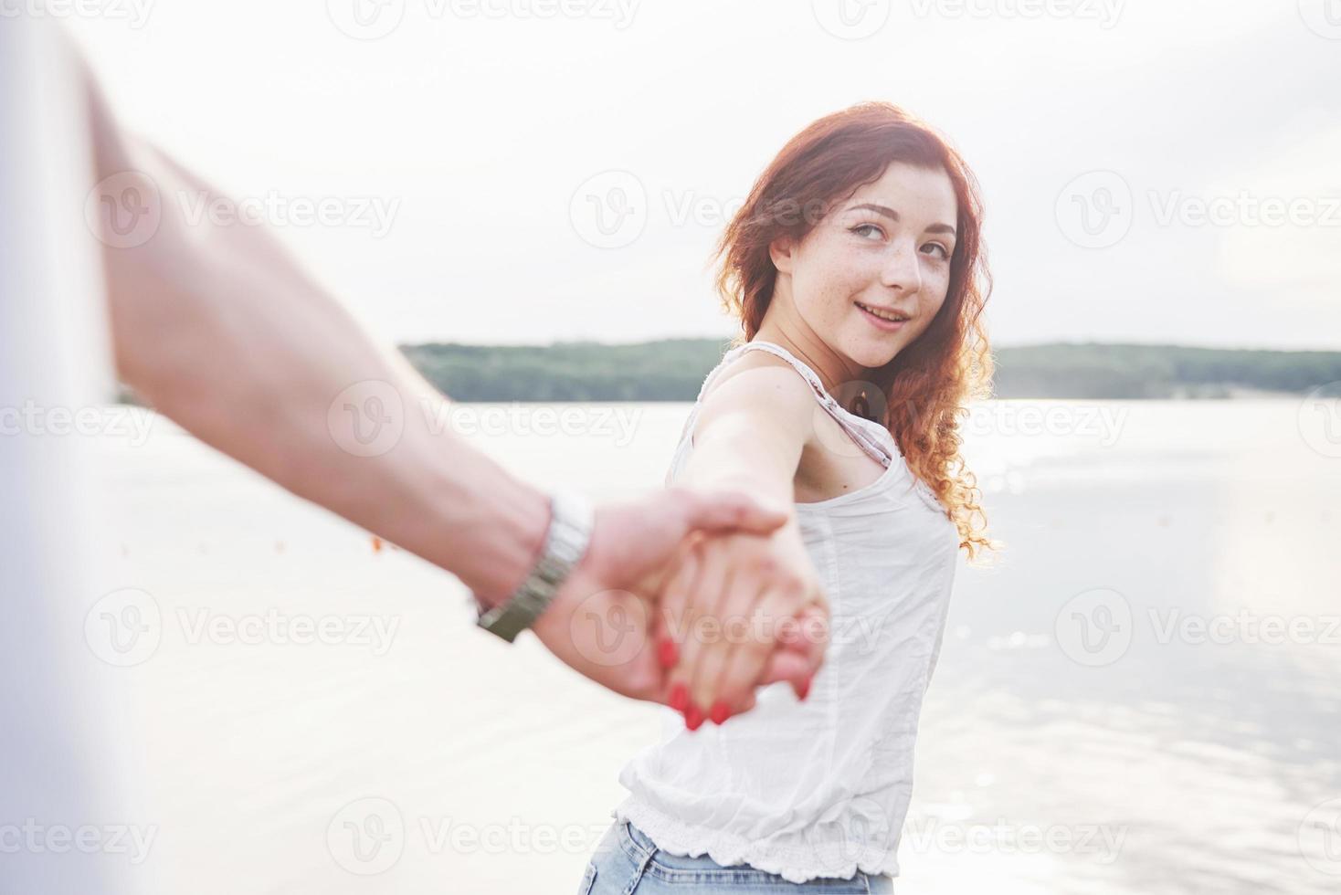 uma mulher sorridente e feliz com uma expressão lúdica e uma mão com o marido. foto
