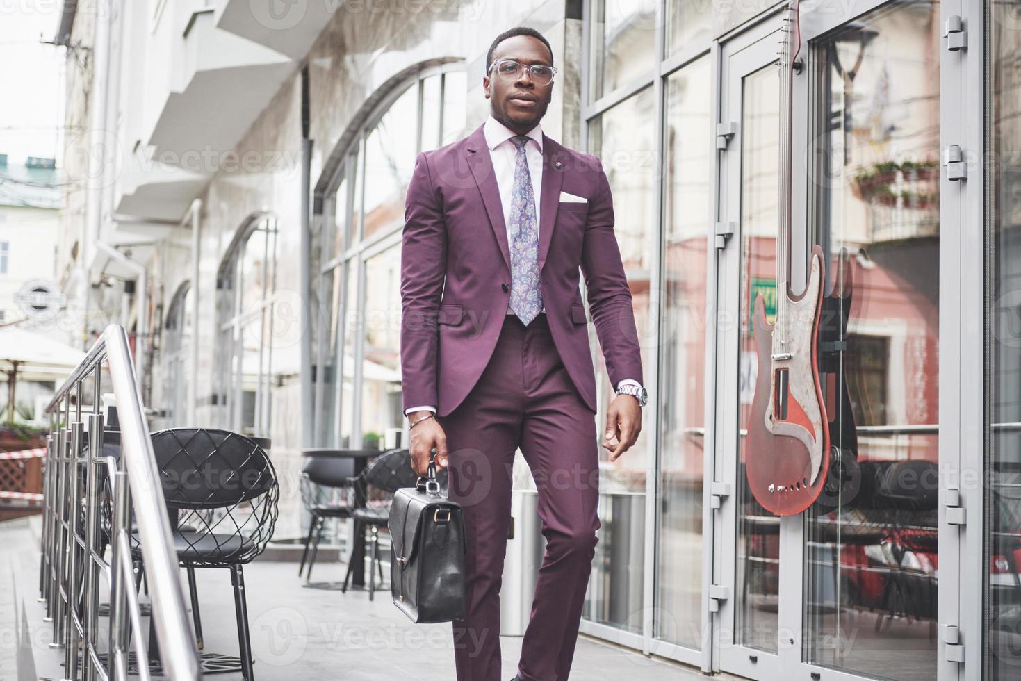 retrato de um jovem empresário afro-americano bonito com uma maleta. reunião de negócios. foto