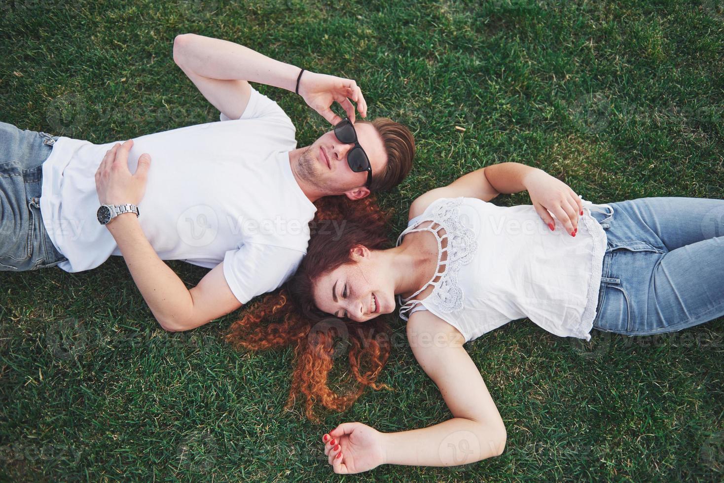 casal alegre deitado na grama. jovens ao ar livre. felicidade e harmonia. foto