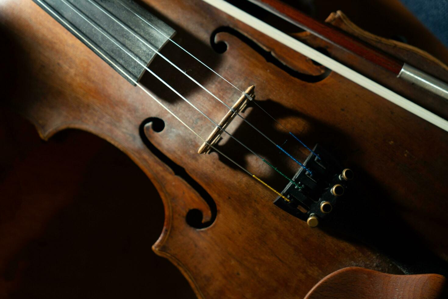 fechar Visão do uma violino cordas e ponte foto