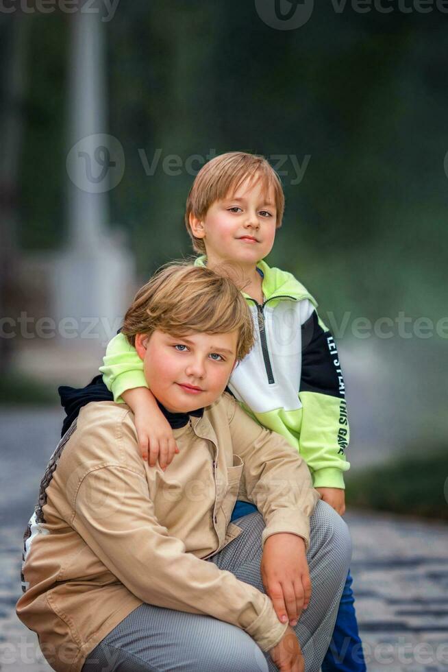 dois irmãos, dois jovem bonito Rapazes do europeu aparência, apreciar gastos Tempo em a rua. Está uma ótimo Tempo para relaxar. foto