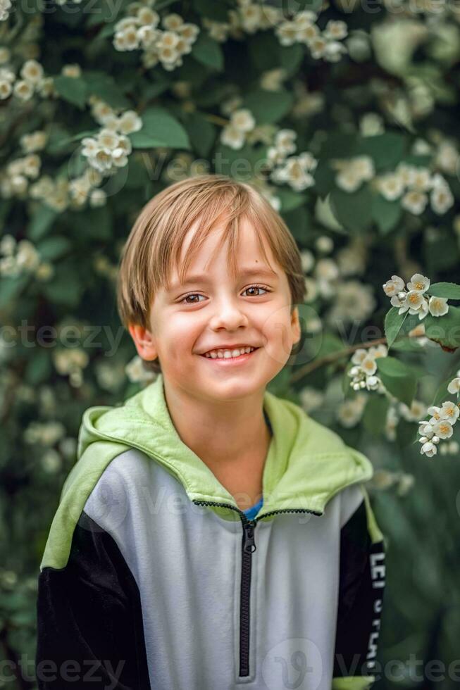 uma jovem bonito Garoto do europeu aparência poses dentro flor dentro natureza. não encenado retratos do uma garoto. Está uma ótimo Tempo para relaxar. foto