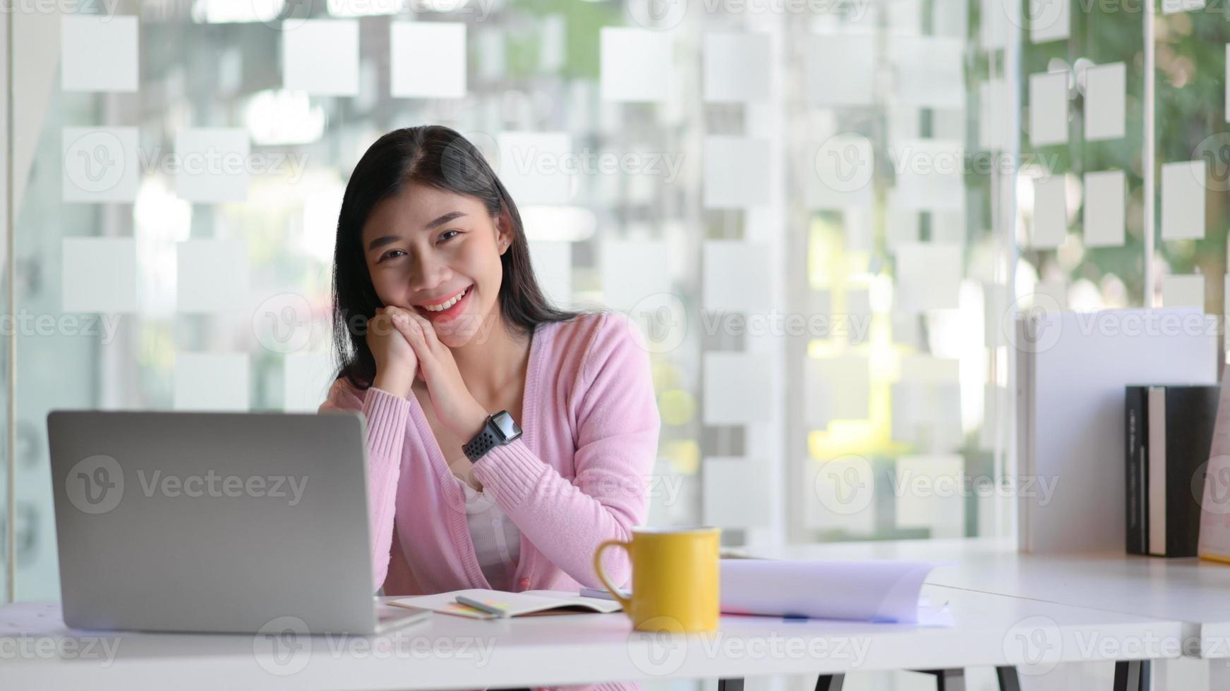 uma jovem aluna com um laptop e café, ela está trabalhando em um projeto de graduação. foto