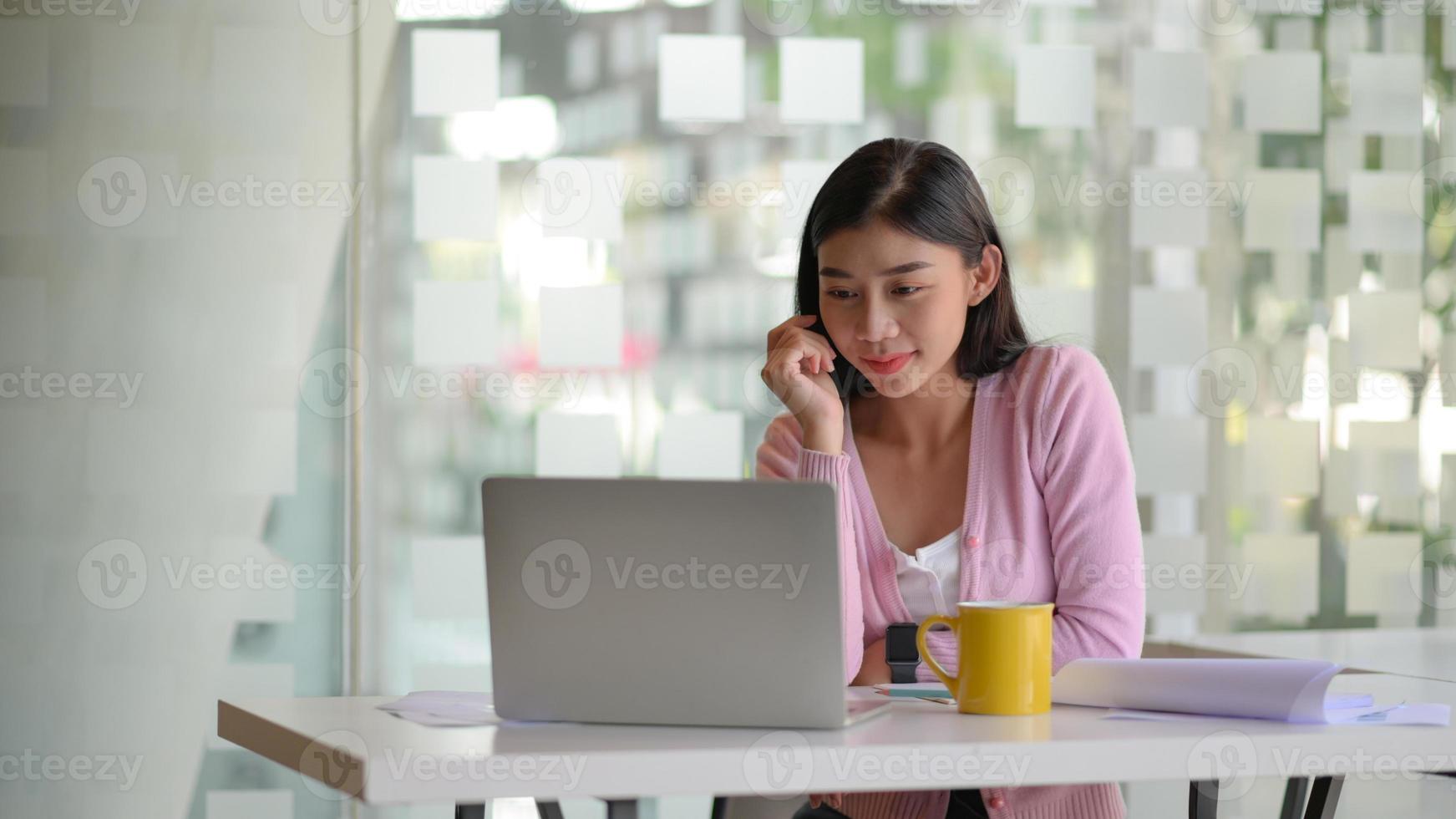 jovens empresárias se concentram em trabalhar um laptop em uma mesa branca em um escritório moderno. foto