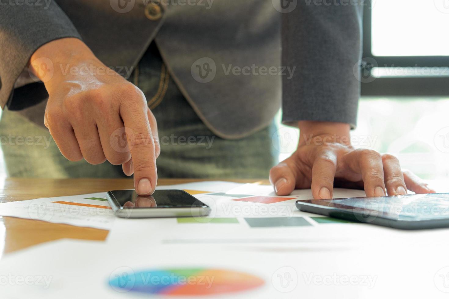 empresários usam o telefone celular em sua mesa no escritório. foto