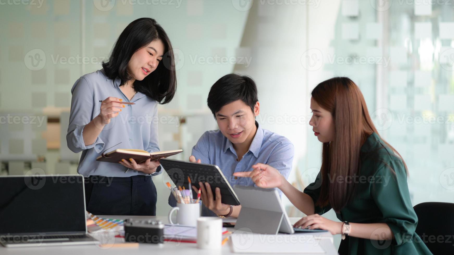 uma equipe de designers profissionais com laptop e dispositivos está fazendo um brainstorming para criar projetos para os clientes. foto