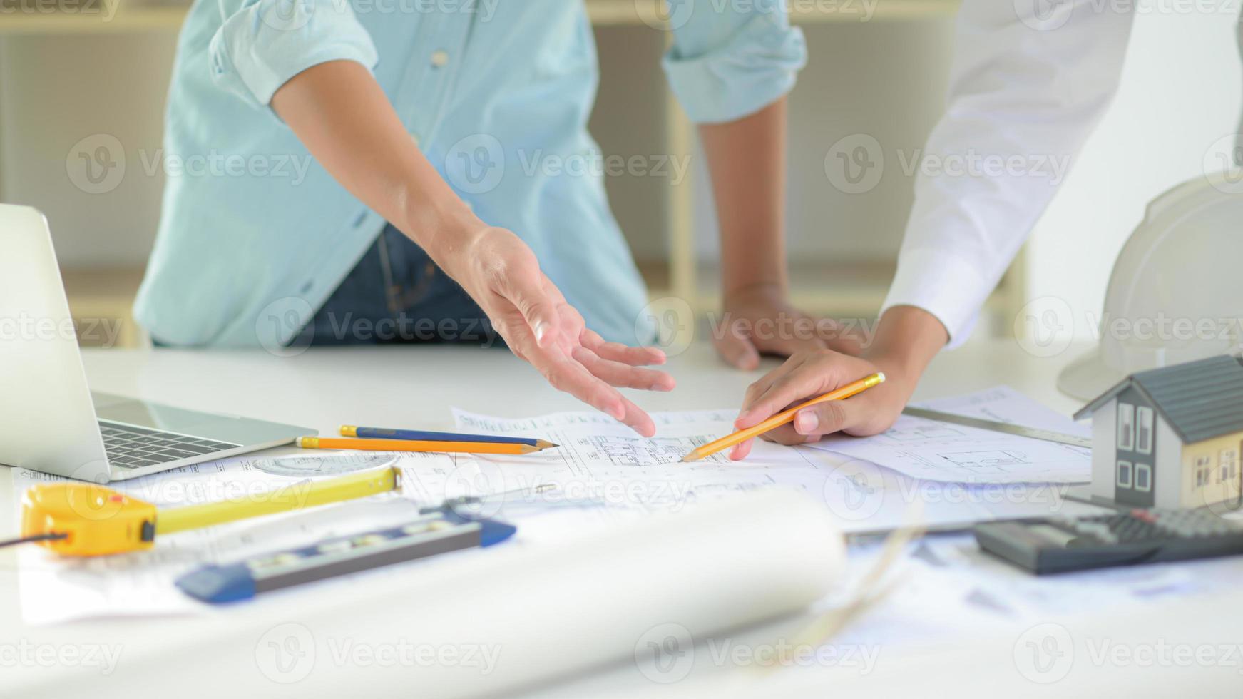 a equipe de designers de casas está discutindo o projeto de planta da casa do cliente. foto