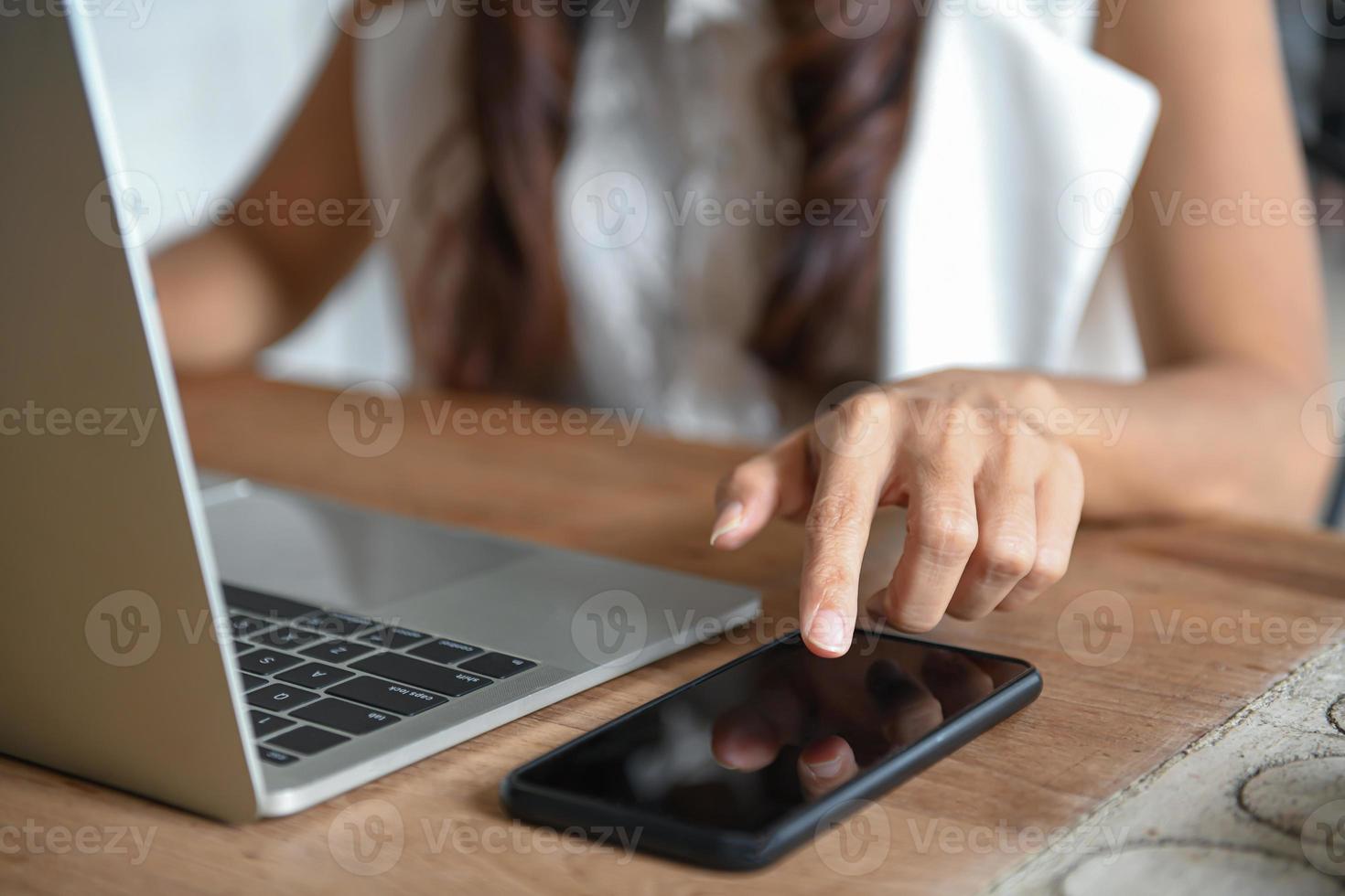 mão de uma mulher de negócios está usando um telefone celular para encontrar informações. foto