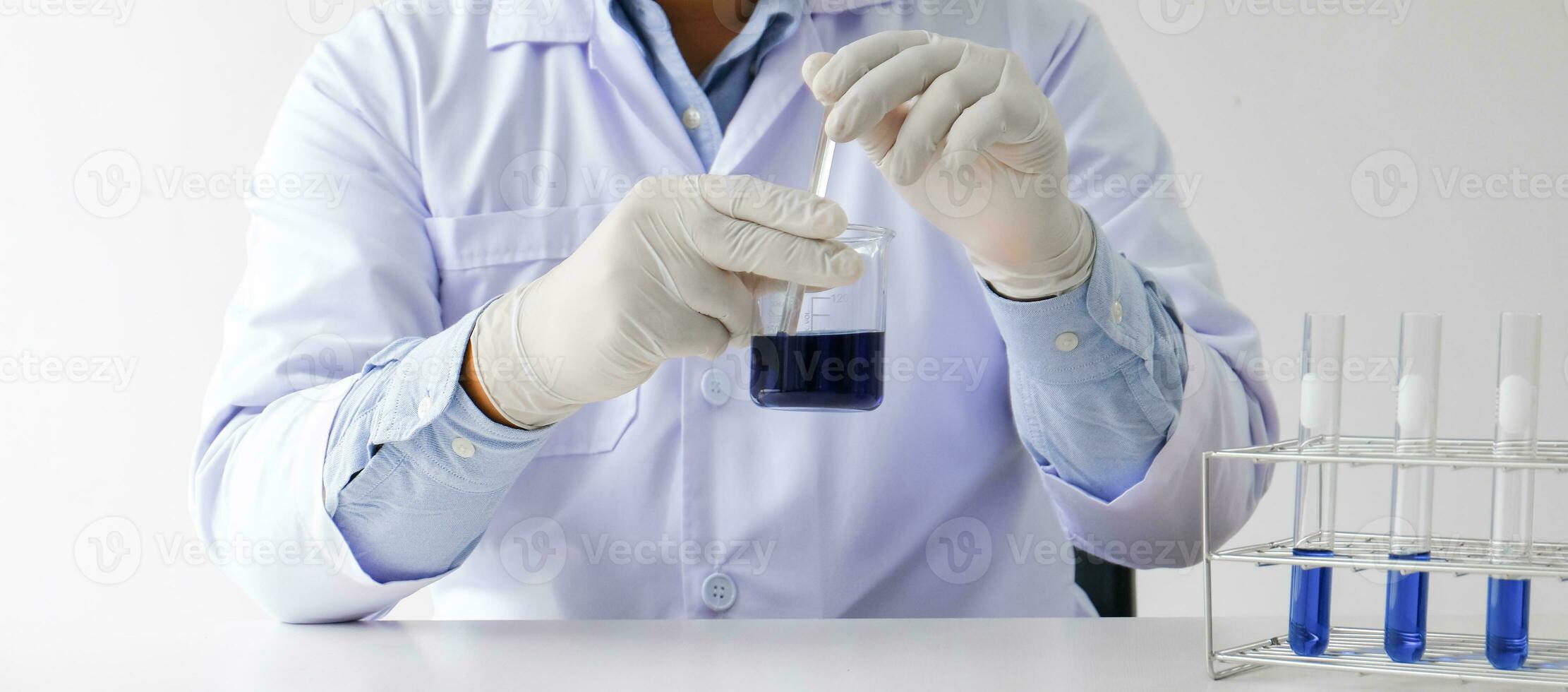 Ciência Inovativa masculino médico ou científico laboratório investigador executa testes com azul líquido dentro laboratório. equipamento Ciência experimentos tecnologia coronavírus covid-19 vacina pesquisa foto