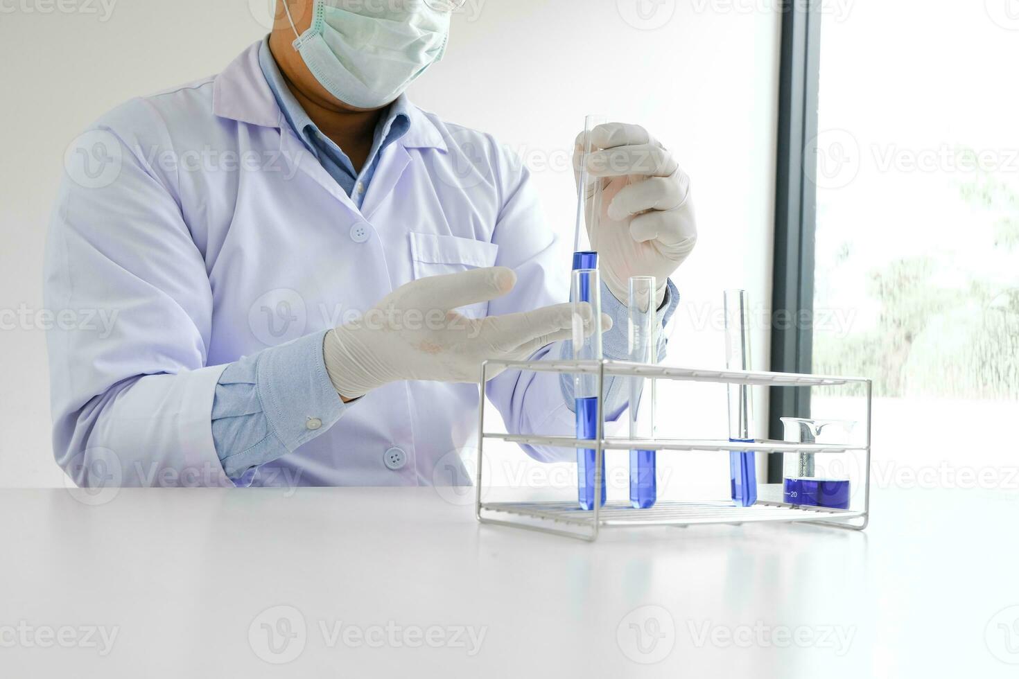 Ciência Inovativa masculino médico ou científico laboratório investigador executa testes com azul líquido dentro laboratório. equipamento Ciência experimentos tecnologia coronavírus covid-19 vacina pesquisa foto