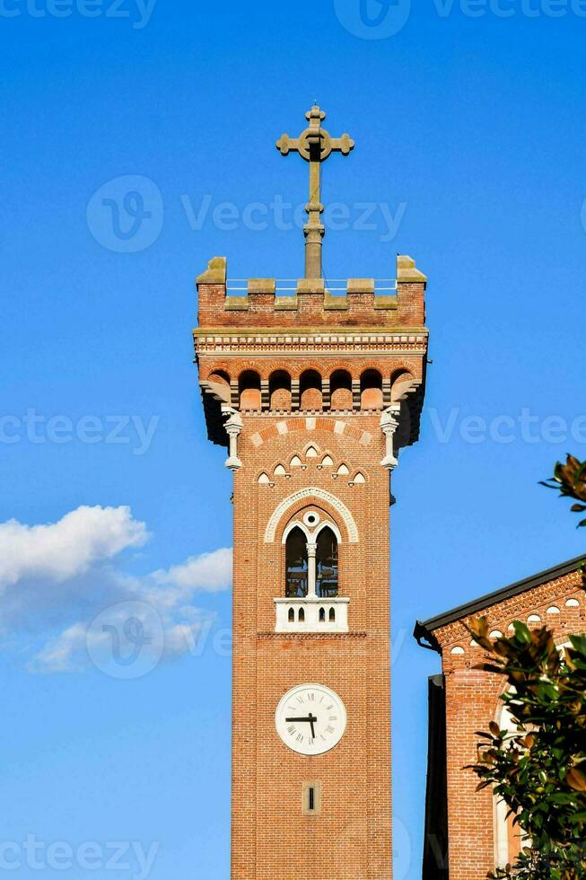 uma relógio torre com uma Cruz em topo do isto foto
