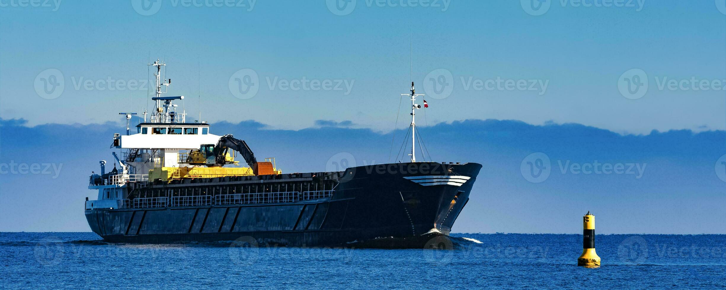 Preto Navegando massa operadora. carga navio com grandes alcance escavadora comovente dentro ainda água às ensolarado dia de a mar foto