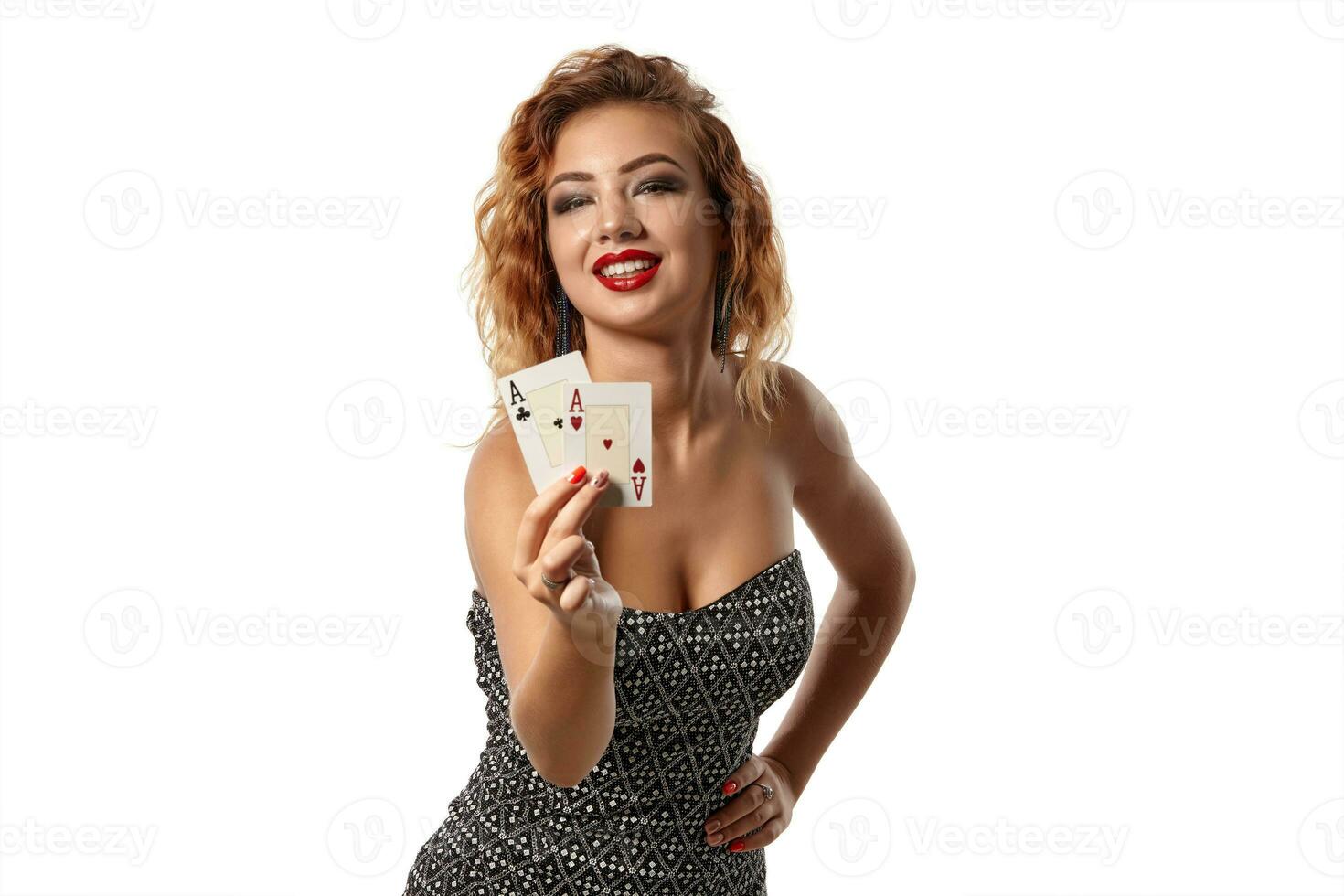 gengibre menina vestindo cinzento vestir é posando segurando dois jogando cartões dentro dela mãos em pé isolado em branco fundo. cassino, pôquer. fechar-se tomada. foto
