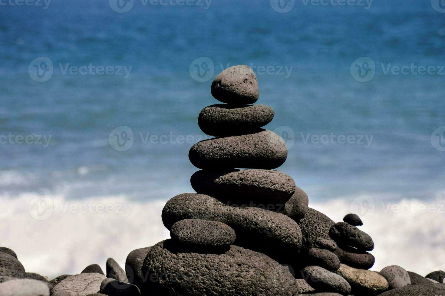 uma pilha do pedras é sentado em a de praia foto