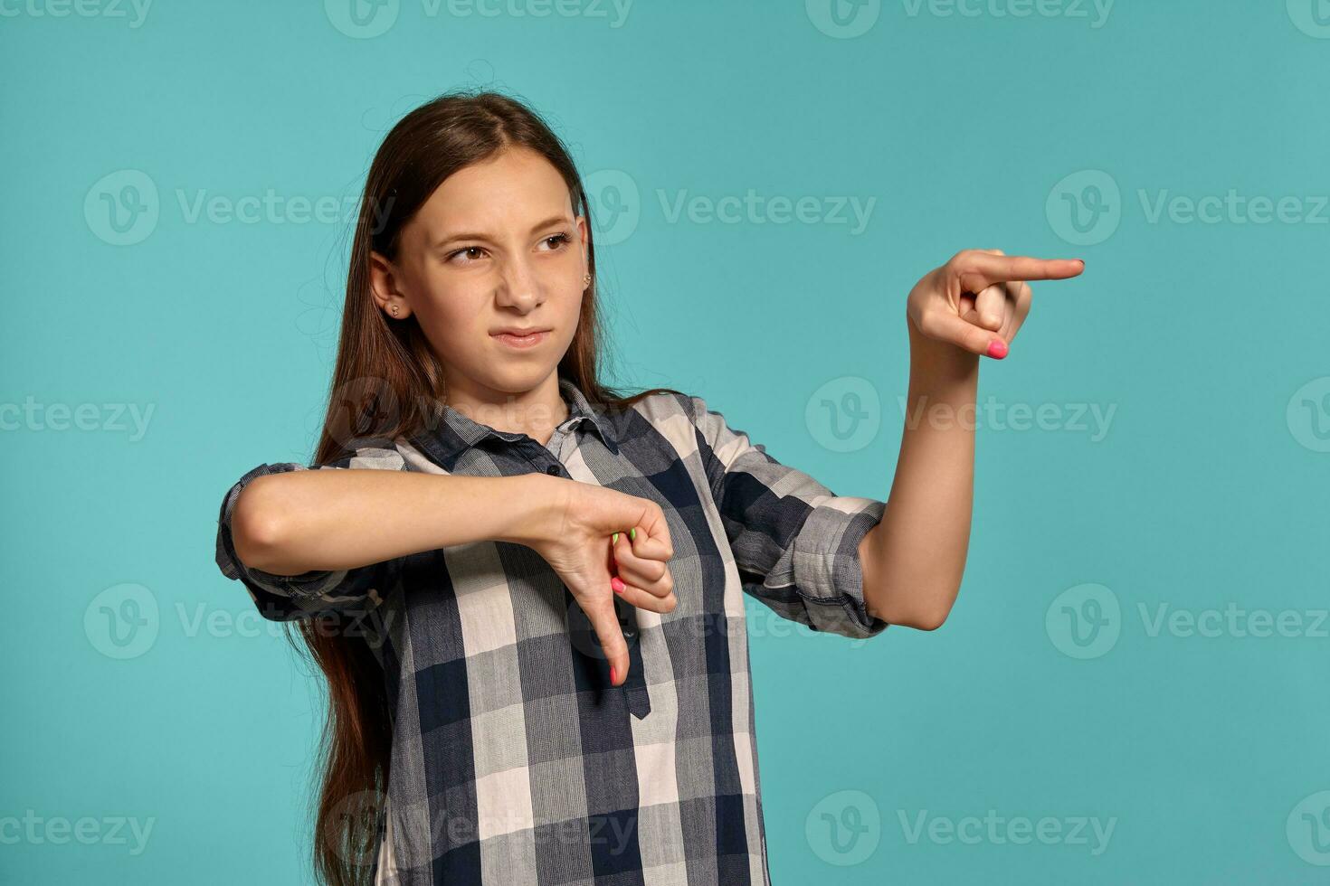 lindo Adolescência menina dentro uma casual xadrez camisa é posando contra uma azul estúdio fundo. foto