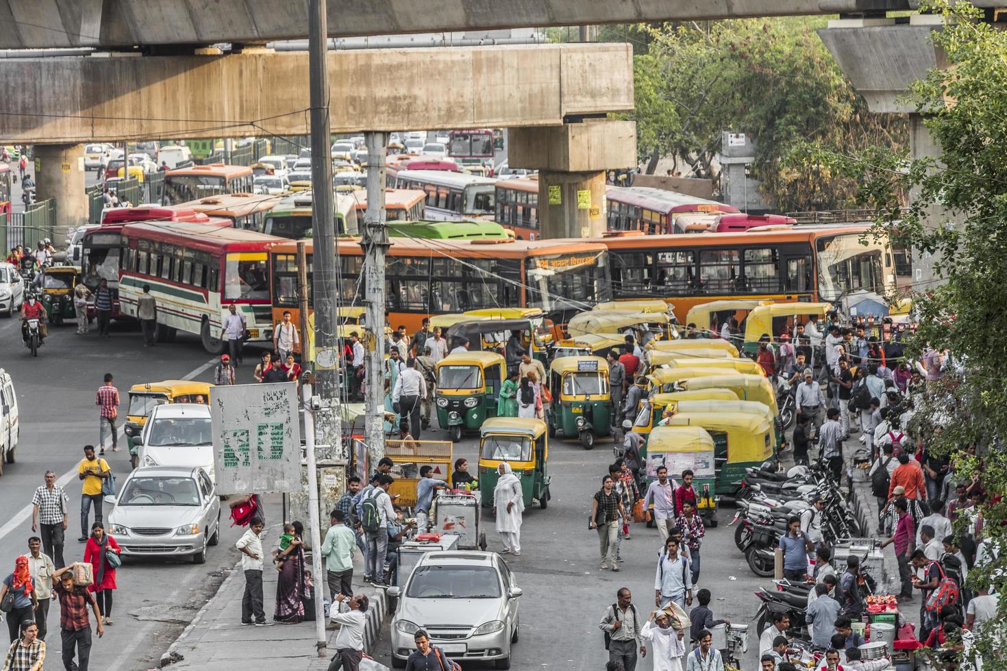 new-delhi delhi india- grande tráfego tuk tuks, ônibus e pessoas foto