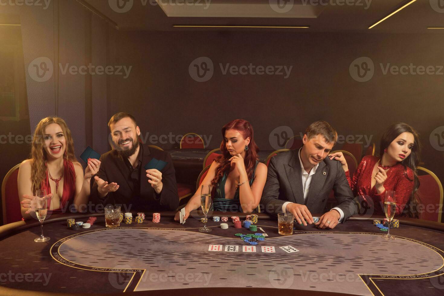 grupo do uma jovem rico amigos estão jogando pôquer às uma casino. foto