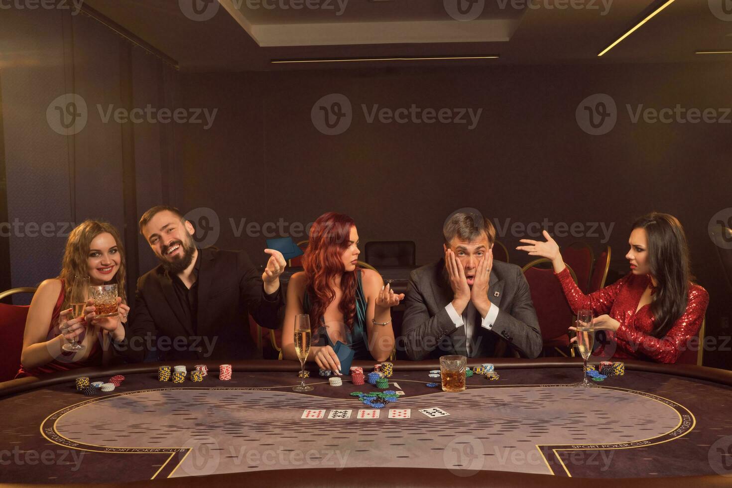 grupo do uma jovem rico amigos estão jogando pôquer às uma casino. foto