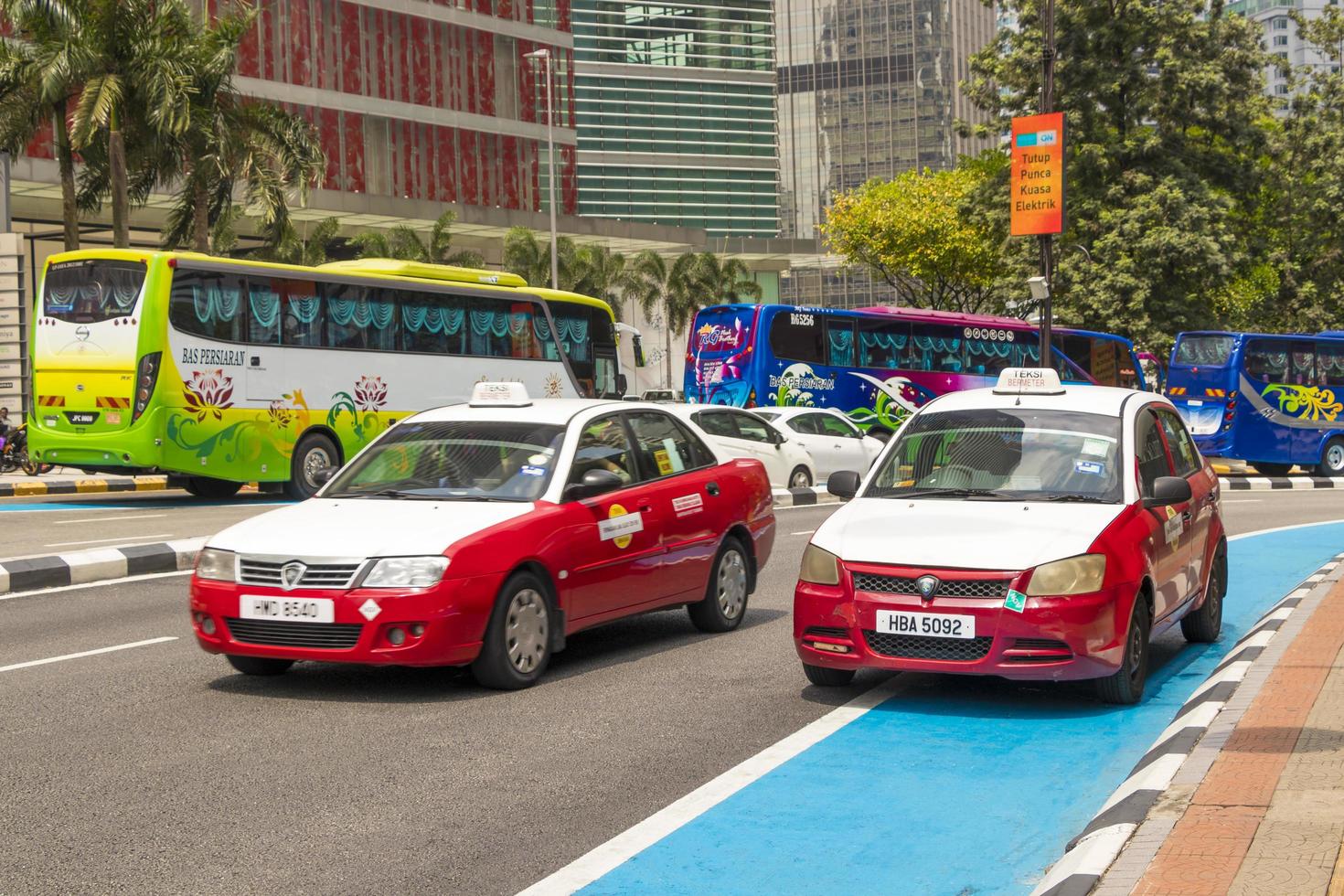 tráfego em Kuala Lumpur. veículos coloridos, carros, táxis e ônibus. foto