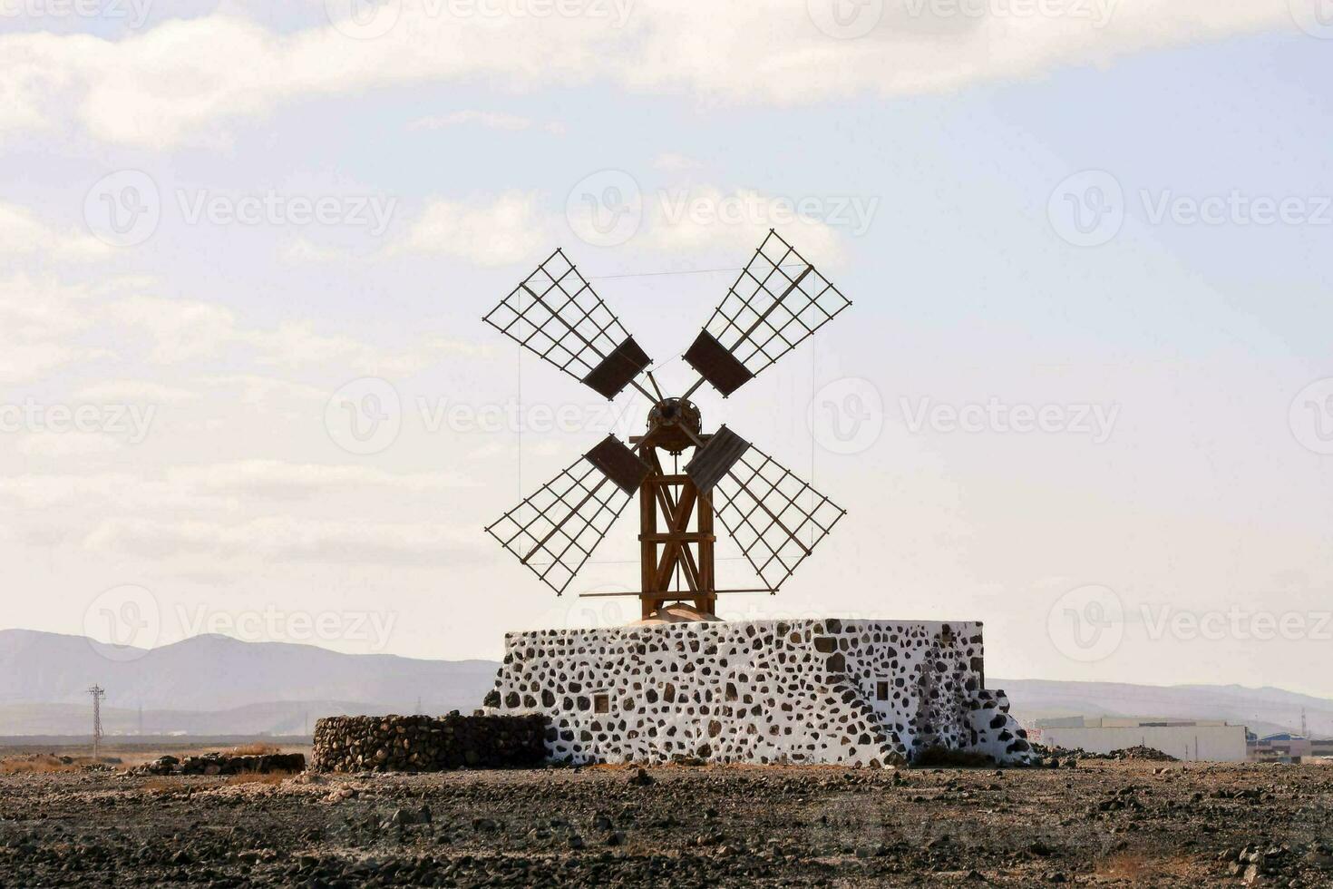 uma moinho de vento dentro a meio do uma deserto foto
