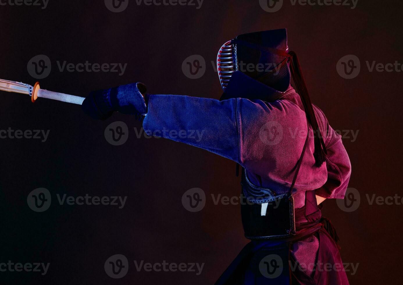 fechar acima tomada, kendo lutador vestindo dentro a armaduras, tradicional quimono, capacete praticando marcial arte com Shinai bambu espada, Preto fundo. foto