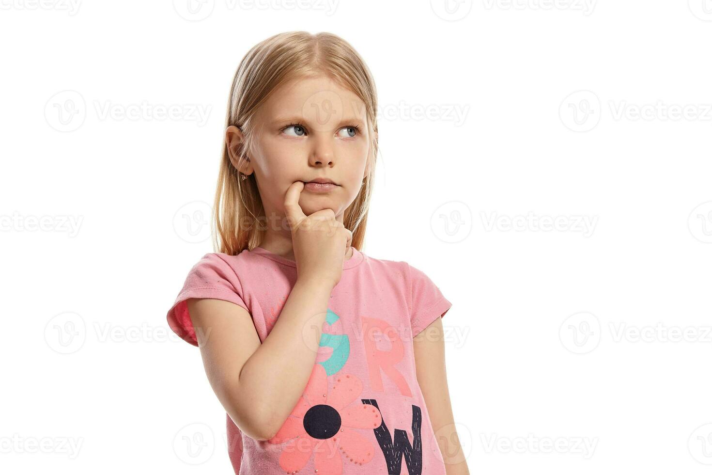 fechar-se retrato do uma agradável Loiras pequeno criança dentro uma Rosa camiseta posando isolado em branco fundo. foto
